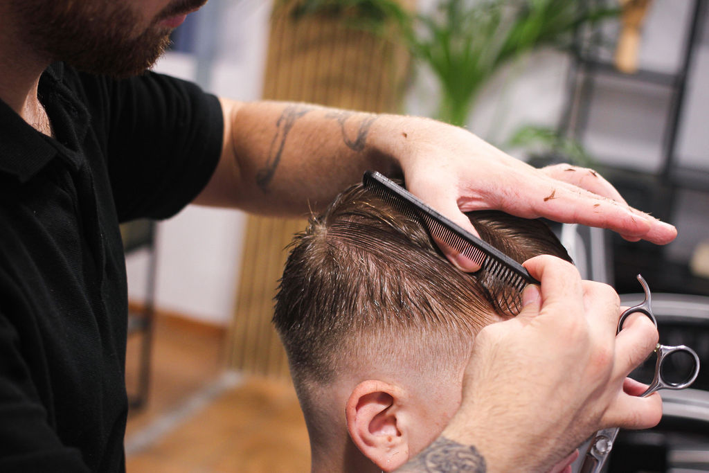 Barber blending a haircut with comb and scissors