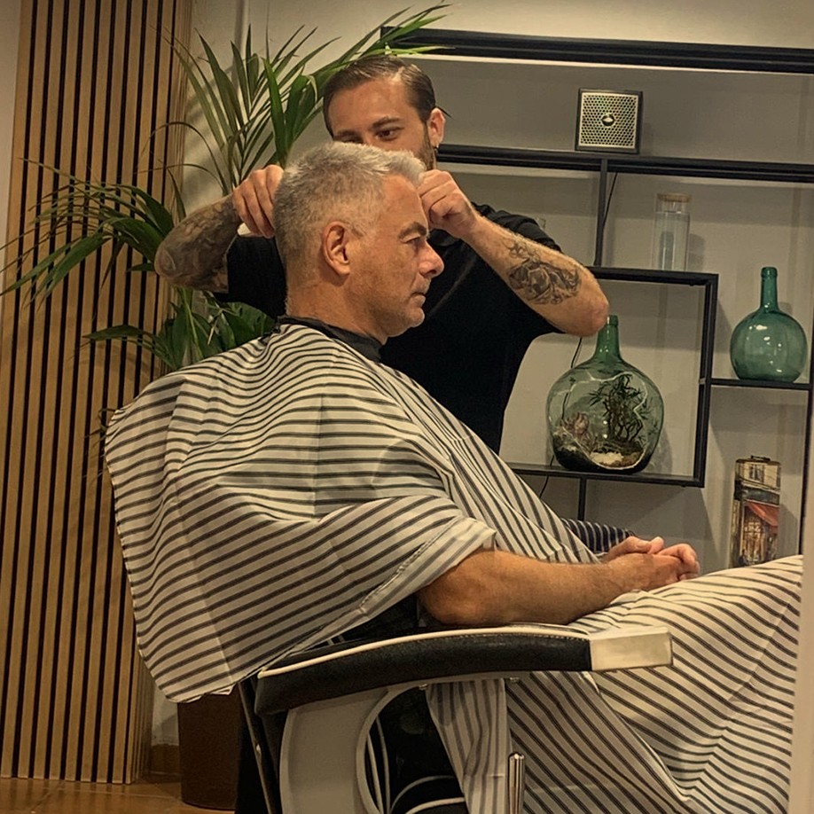 Barber scissors and comb resting on dark leather